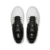 On THE ROGER Clubhouse men's tennis shoes in black with white accents, featuring breathable mesh and cushioned soles.