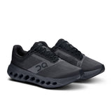 Women's On Cloudsurfer Next road running shoes in black and white with cushioned sole and breathable mesh upper.