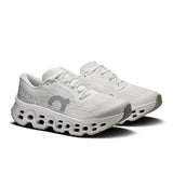 Women's On Cloudmonster 3 road running shoes with cloud cushioning in black and pink, featuring breathable mesh upper and supportive sole.