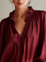 Long sleeve blouse with frill and notched details by Trendsi, featuring a stylish, feminine design in soft fabric.
