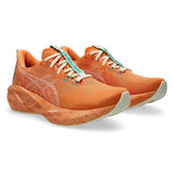 Unisex ASICS Novablast 5 Tokyo neutral daily trainers in Sun Peach and White with breathable mesh upper and cushioned sole.