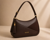 Brown Bagsor curved shoulder bag with tassel detail, featuring a stylish design and adjustable strap.