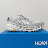 Hoka Women's Speedgoat 6 trail running shoes in B-width with purple and black design, showing the side view and outsole.