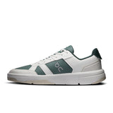 On THE ROGER Clubhouse men's tennis shoes in white with blue accents, featuring cushioned soles and breathable mesh uppers.