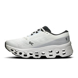 Women's On Cloudmonster 3 road running shoes with grey and black design, featuring cushioned soles and breathable mesh uppers.