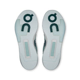 On THE ROGER Clubhouse Pro 2 men's tennis shoes with white and blue design, featuring cushioned soles and athletic performance details.