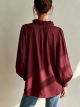 Trendsi frill notched long sleeve blouse with ruffled collar and button details, shown in a close-up of the fabric and design.