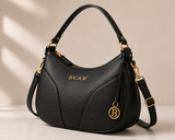 Black Bagsor curved handbag with gold-tone hardware and sleek design, featuring top handles and a structured shape.